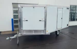 front view of white drive on/off enclosed snowmobile trailer