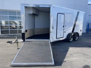 front 3/4 view of Aluminum Enclosed Snowmobile Trailer- White with one of the front ramps down